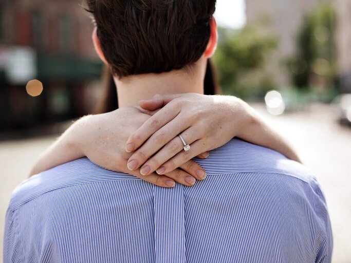 Frau umarmt Mann mit Ring an der Hand | © Getty Images/Jami Saunders