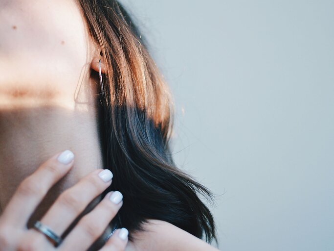 Frau greift sich mit Hand an den Hals | © Getty Images/Polina Radcenko / EyeEm