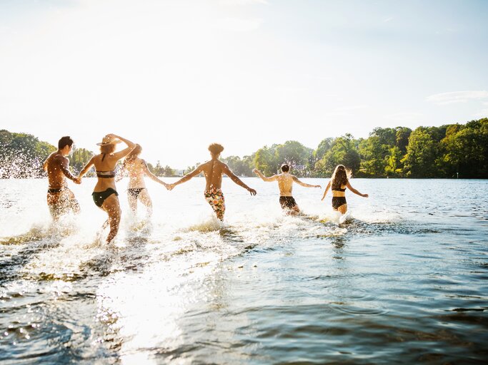 Gruppe von Freunden springt ins Wasser | © Getty Images/Hinterhaus Productions