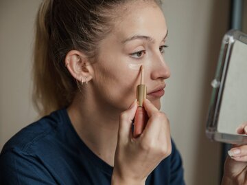 Frau trögt Concealer aus | © Getty Images/DGLimages