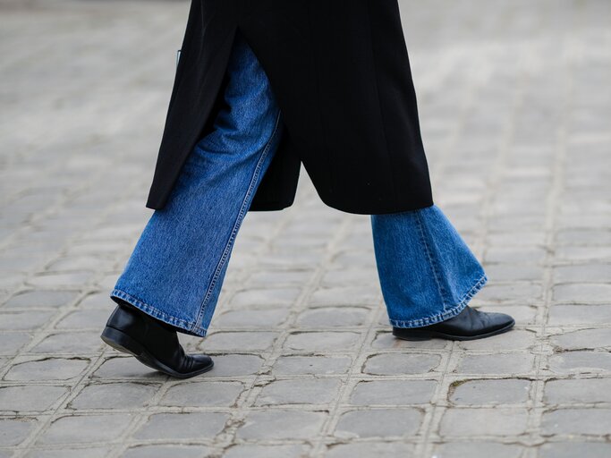 Frau mit Schlaghose und schwarzen Stiefeln | © Getty Images/Edward Berthelot 