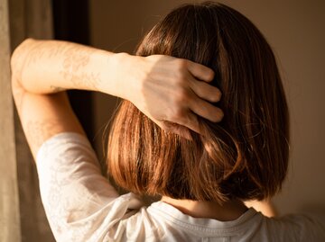 Frau hält sich ihre Haare | © Getty Images/Photographer, Basak Gurbuz Derman