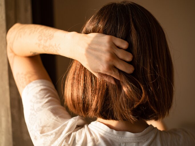 Frau hält sich ihre Haare | © Getty Images/Photographer, Basak Gurbuz Derman