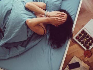 Frau liegt traurig im Bett | © Getty Images/martin-dm