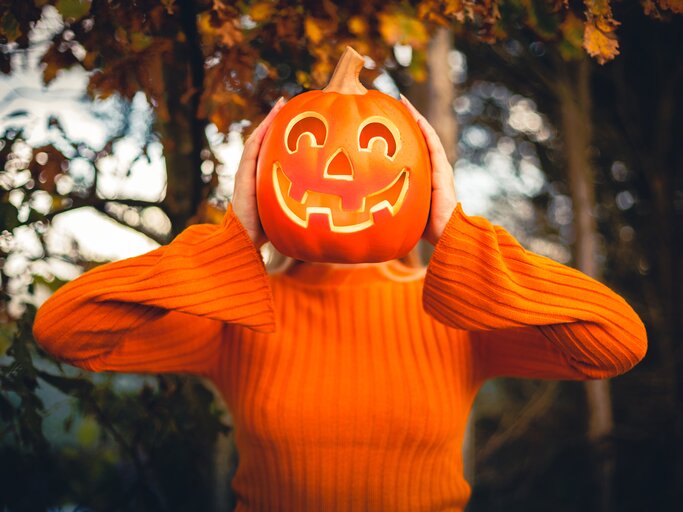 Frau hält unheimlichen Halloween-Kürbis | © Getty Images/Circle Creative Studio