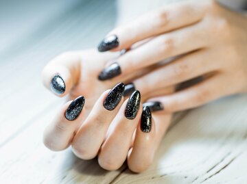 Schwarze Nägel mit Glitzer | © PhotoJuli86/Shutterstock