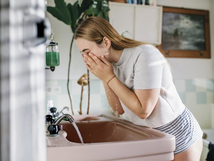 Frau wäscht sich Gesicht im Badezimmer | © Getty Images/Willie B. Thomas