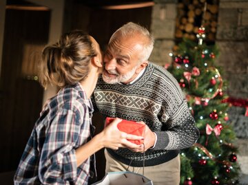 Tochter umarmt ihren Vater an Weihnachten | © Getty Images/ilbusca