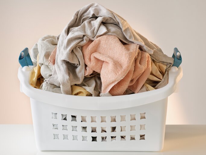 Wäschekorb voller Wäsche | © Getty Images/Tetra Images
