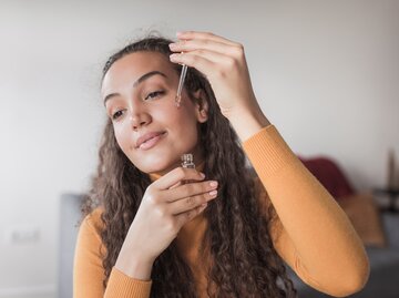 Frau trägt Gesichtsöl auf | © Getty Images/Dobrila Vignjevic