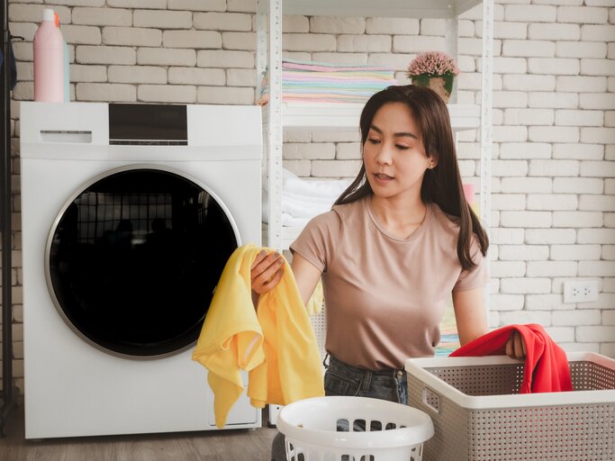 Frau ist in der Waschküche und macht Wäsche | © Getty Images/Supawat Punnanon / EyeEm