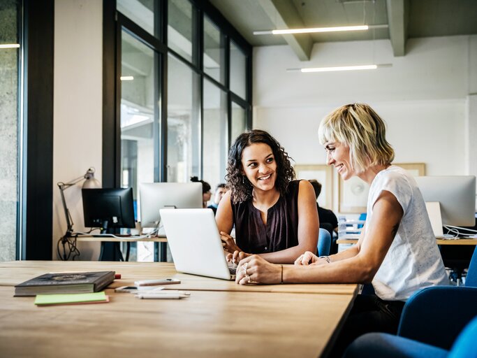 Zwei Businessfrauen tauschen sich aus | © Getty Images/Tom Werner