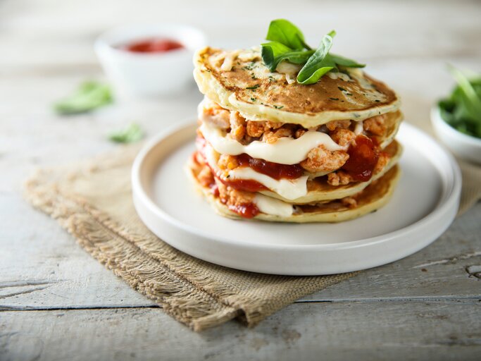 Pfannkuchen-Turm mit Käse und Tomaten belegt | © Shutterstock.com/MariaKovaleva