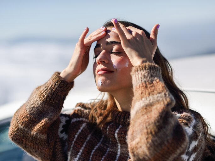 Frau trägt sich Feuchtigkeitscreme im Winter auf | © Getty Images/Javier Sánchez Mingorance / EyeEm