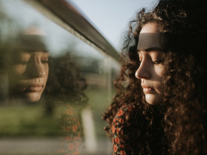 Frau blickt traurig aus dem Fenster | © Getty Images/	Levani Kalmaxelidze / EyeEm