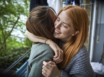 Zwei Freundinnen umarmen sich und lachen  | © Getty Images/	Oliver Rossi
