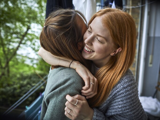Zwei Freundinnen umarmen sich und lachen  | © Getty Images/	Oliver Rossi
