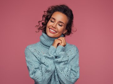 Schöne Frau mit einem romantischen Lächeln | © Getty Images/CoffeeAndMilk