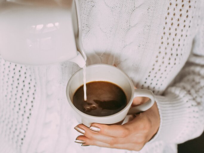 Frau gießt Milch in ihren Kaffee | © Getty Images/Barbara Jovanovic / EyeEm