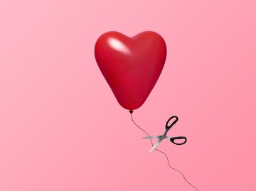 Herzluftballon wird mit einer Schere durchgeschnitten | © Getty Images/	J Studios