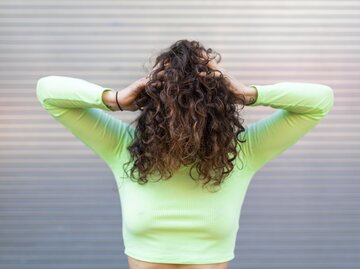 Frau wirft sich ihre Locken über den Kopf | © Getty Images/	Westend61