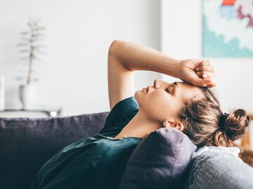 Frau sitzt traurig auf dem Sofa | © Getty Images/	Maria Korneeva