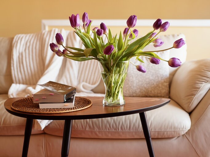 Vase mit Tulpen steht auf einem Beistelltisch | © Getty Images/	Natalia Ganelin