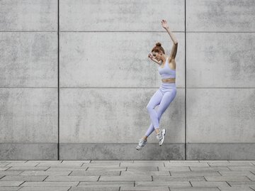 Sportliche Frau springt in die Luft | © Getty Images/	Klaus Vedfelt