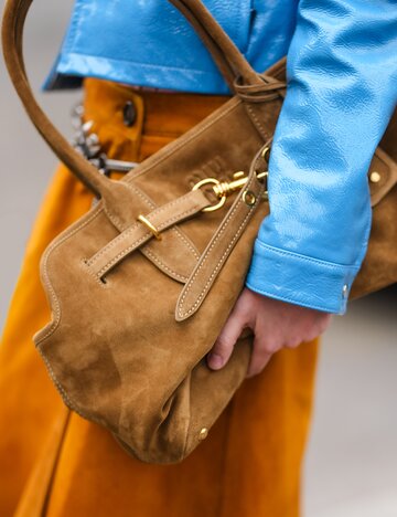 Streetstyle von brauner "Aventure"-Tasche aus Wildleder von Miu Miu | © Getty Images/Edward Berthelot
