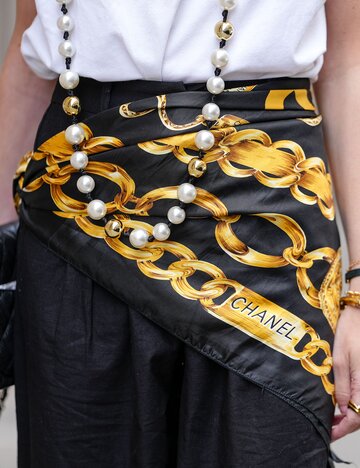 Streetstyle von Alba Garavito Torre mit um die Hüfte gebundenem Seidentuch | © Getty Images/Edward Berthelot