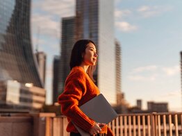 Person mit Laptop vor Skyline | © Getty Images/Oscar Wong