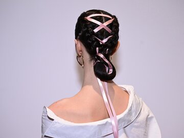 Ein Model trägt den Frisurentrend Ribbon Hair auf der Fashion Week. | © GettyImages/Dave Kotinsky / Freier Fotograf
