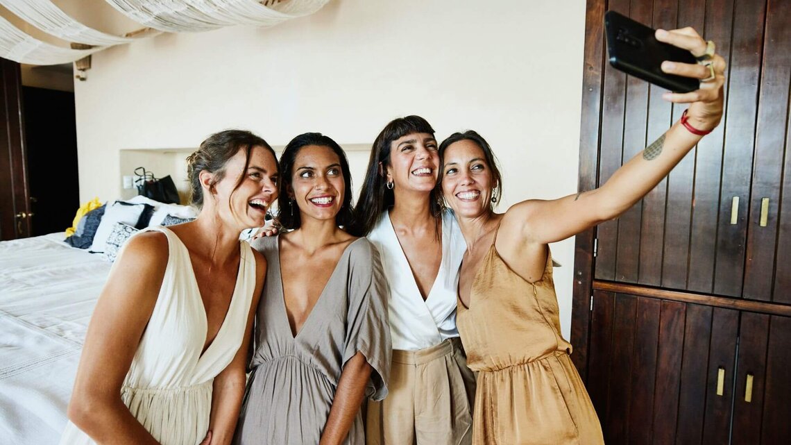Gruppe auf Hochzeit macht Selfie | © Getty Images/Thomas Barwick