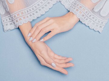 Frauenhände mit lackierten Fingernägeln Farbton Bluberry Milk | © Getty Images/Ksenia Lyubasova