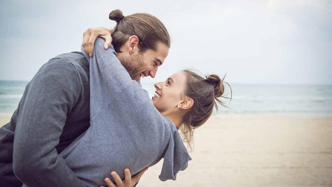 Junges Paar umarmt und lächelt sich an | © Getty Images/Jacobs Stock Photography Ltd