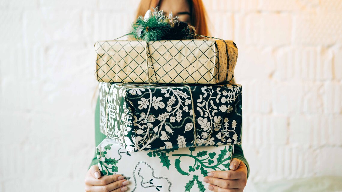 Frau mit vielen Geschenken in der Hand | © Getty Images/Fiordaliso