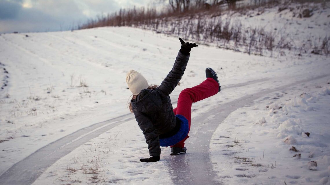 Frau rutscht im Schnee aus | © Adobe Stock/STOATPHOTO