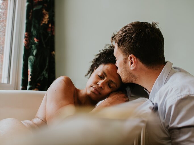 Mann küsst Partnerin auf die Stirn | © Getty Images/Catherine Falls Commercial