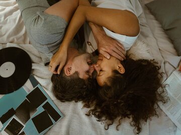 Paar liegt auf Bett | © Getty Images/Maskot