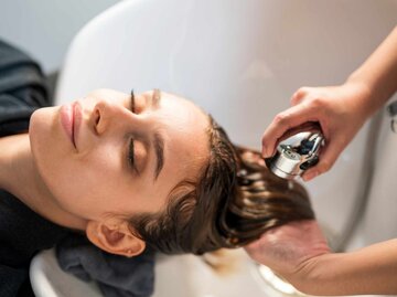 Junge Frau bekommt beim Friseur die Haare gewaschen | © Getty Images/Nitat Termmee