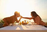 Pärchen in der Sonne isst zusammen am Tisch | © gettyimages.de |Colin Anderson Productions pty ltd