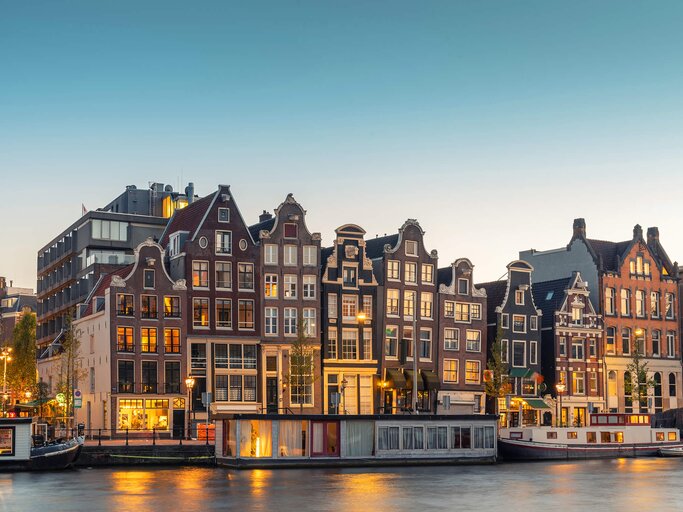 Grachtenhäuser in Amsterdam im Abendlich | © Getty Images | George Pachantouris