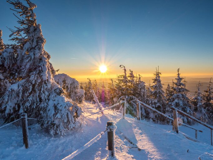Blick auf verschneite Bergspitze und Wintertouristen im Erzgebirge bei Sonnenschein | © iStock | Animaflora