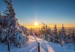 Blick auf verschneite Bergspitze und Wintertouristen im Erzgebirge bei Sonnenschein | © iStock | Animaflora