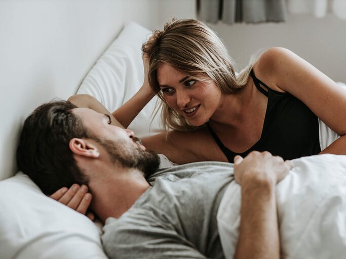Paar liegt im Bett und unterhält sich.  | © iStock | Erdark