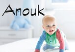 Glückliches Baby krabbelt im Bett - dazu der Name Anouk | © iStock | FamVeld