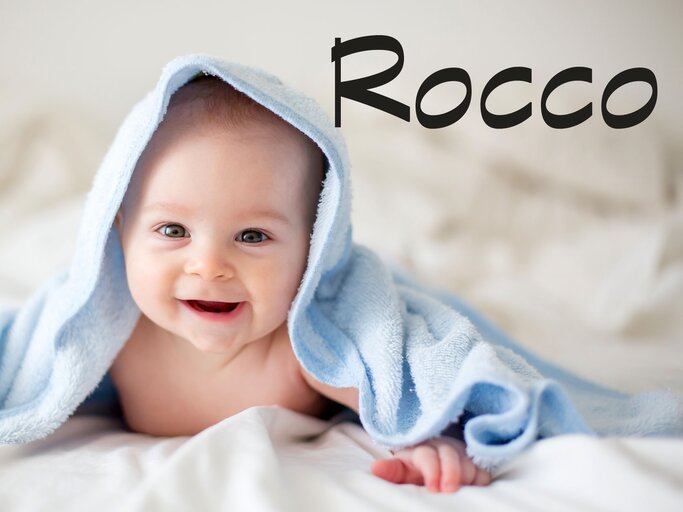 Baby, eingewickelt mit einem Handtuch - dazu der Jungenname Rocco | © iStock | tatyana_tomsickova