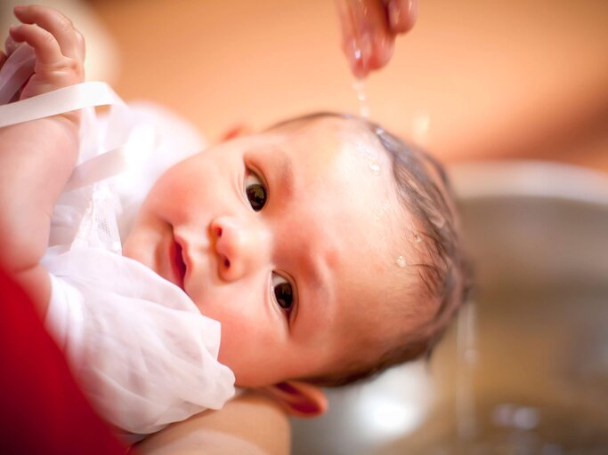 Ein sechs Monate altes Baby wird in einer Kirche getauft. | © iStock | JasonDoiy