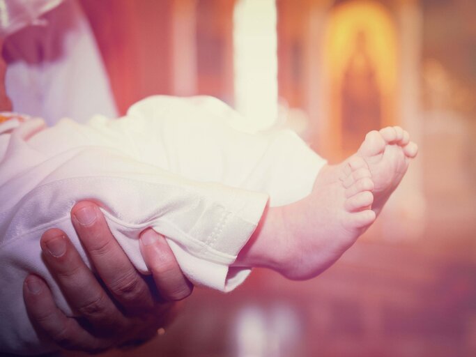 Die Füße eines Babys bei seiner Taufe. | © iStock.com / Aleksandr_Gromov