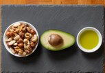 Avocado, gemischten Nüssen und Olivenöl auf Tischplatte | © iStock.com | IGphotography